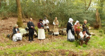 Group of people in nineteenth century costume, in a clearing